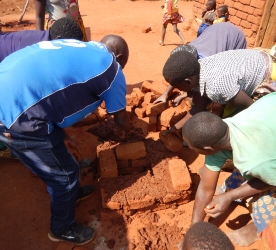 4. village women building large stove with Peter